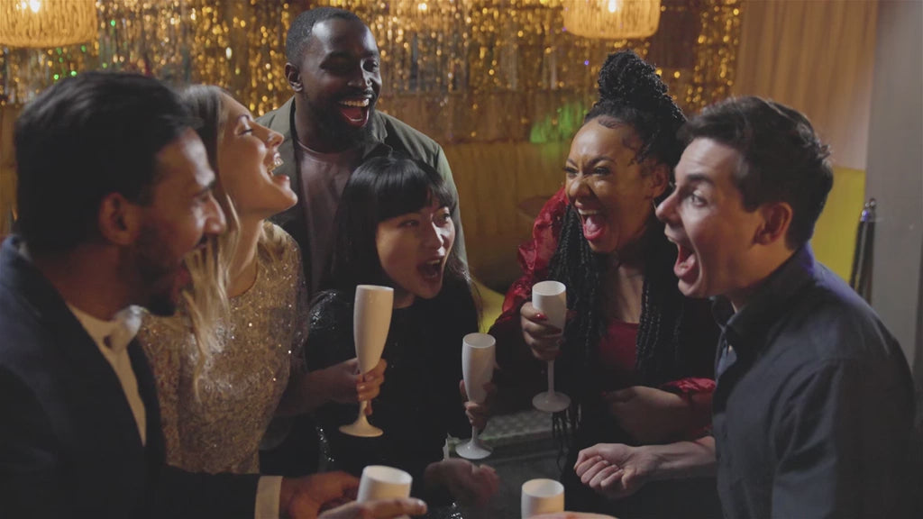 Group of friends celebrating and laughing at a party with champagne glasses — perfect nightlife scene for Hangover Helper by Happy Strips